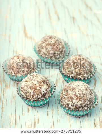 Handmade energy balls made from moroccan dates, almond and coconut truffles on retro wooden background