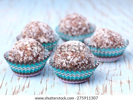 Handmade coconut snow balls made from moroccan dates, almond and coconut truffles on wooden surface
