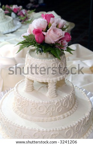 white wedding cake with roses on the top layer