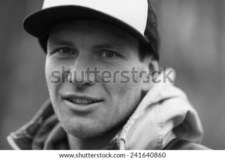 Pensive man in a trucker cap. Black and white close-up portrait
