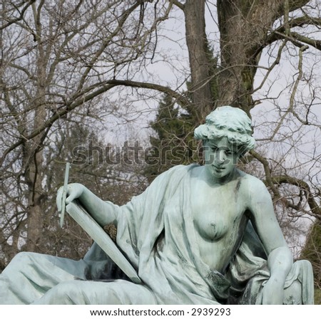 bronze statue woman at graveside holding book and pen