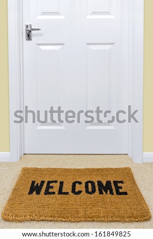 A Welcome doormat in front of a door.