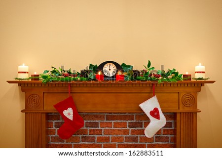 Christmas stockings hanging over the fireplace at midnight on Christmas Eve, the mantlepiece is decorated with festive holly and ivy garland plus candles. Plenty of copy space to add your own message.