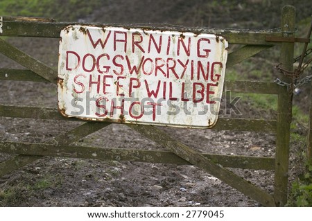 Sign on an old farm gate about dogs and sheep