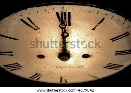 Antique clock face with the hands at 12 o\'clock, sepia toned image.
