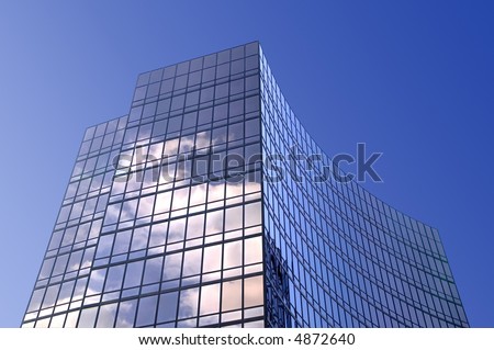 Modern smoked glass office building set against a blue sky.