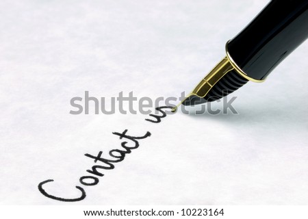 \'Contact Us\' written on watermarked textured paper using a gold nibbed fountain pen. Focal point is on the text.
