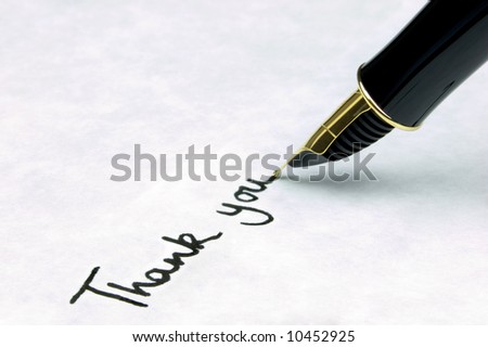 \'Thank You\' written on watermarked textured paper using a gold nibbed fountain pen. Focal point is on the text.