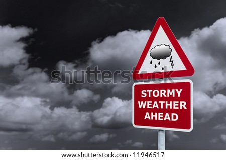 Concept image of a signpost with Stormy Weather Ahead against a dark cloudy sky.