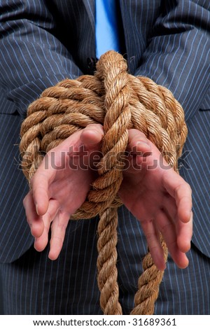 Close up of a businessmans hands tied with rope