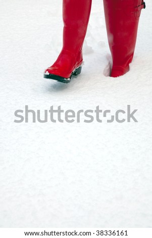 A pair of red wellington boots in the snow plenty of copy space