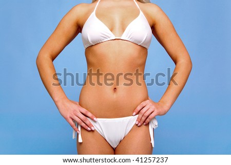 Body of a female in a white bikini with a golden tan against a blue background.