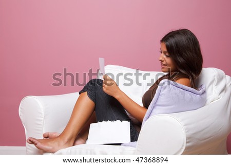 Women sat in an armchair reading a letter, blank envelope to add your own text.