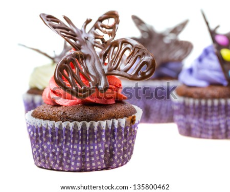Chocolate butterfly decorated cupcakes on white background