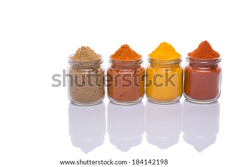 Mixed powdered spices in glass container on white background