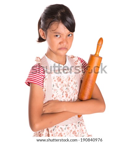 Young Asian Malay girl wearing kitchen apron with a wooden rolling pin over white background