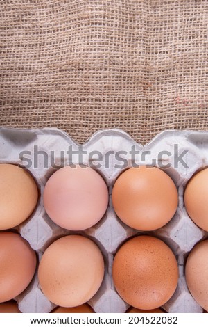 Chicken eggs in egg carton on gunny sack