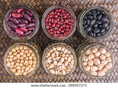Black eye peas, chickpeas, adzuki beans, soy beans, black beans and red kidney beans in mason jars on wicker tray