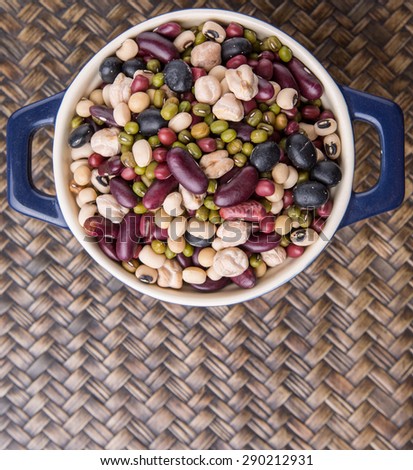 Mix bean of black eye peas, mung bean, adzuki beans, soy beans, black beans and red kidney beans in a blue pot over wicker background