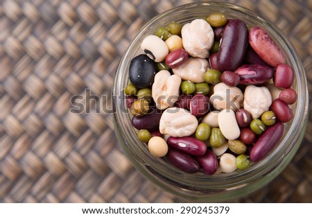 Mix bean of black eye peas, mung bean, adzuki beans, soy beans, black beans and red kidney beans in a mason jar over wicker background