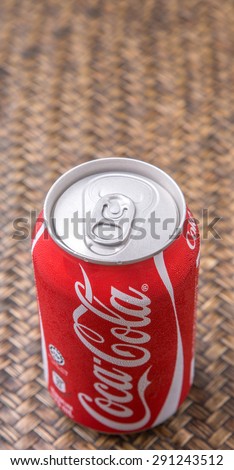 PUTRAJAYA, MALAYSIA - JUNE 28TH, 2015. Coca Cola can on wicker background. Coca Cola drinks are produced and manufactured by The Coca-Cola Company, an American multinational beverage corporation.