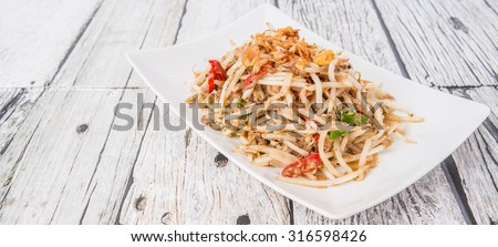 Malaysian dish bean sprout salad or local name Kerabu Taugeh in a white plate over wooden background