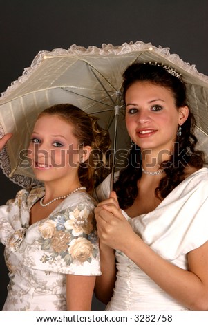 Teenage sisters in period costumes with jewelry and parasol