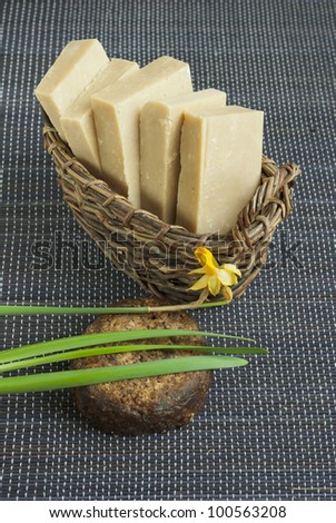 natural soaps in wooden basket and african black soap, textured background