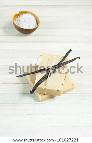 natural soap with vanilla beans and bath salts, bright wooden background