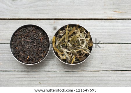 black, green tea leaves, wooden table background