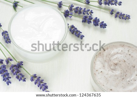 face cream and hand cream with blue lavender flowers on white textile background