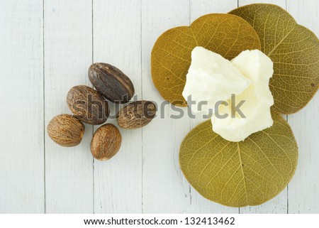 shea butter nuts and shea butter natural moisturizer on white wood