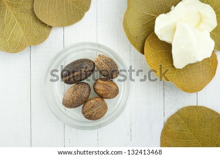 shea butter nuts and shea butter natural moisturizer on white wood