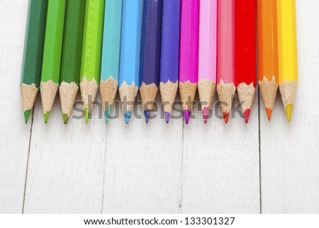 color pencils on white wooden table directly above