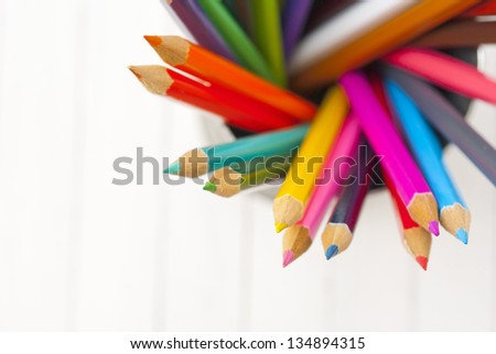 color pencils in tin can, white wood table, directly above