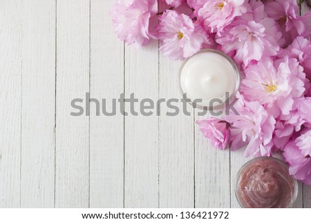 cosmetic cream with japanese cherry blossoms on white wooden table