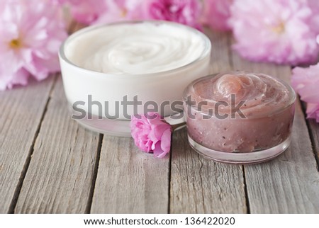 cosmetic cream with japanese cherry blossoms on old weathered wooden table background