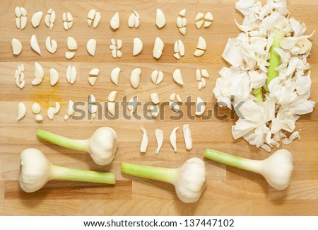 sliced garlics on extra virgin olive oil, wooden table, directly above