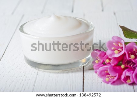 cosmetic cream on white wood table