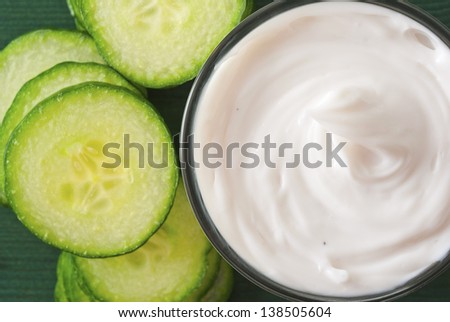 acne cream in glass jar with cucumber slices, wood table