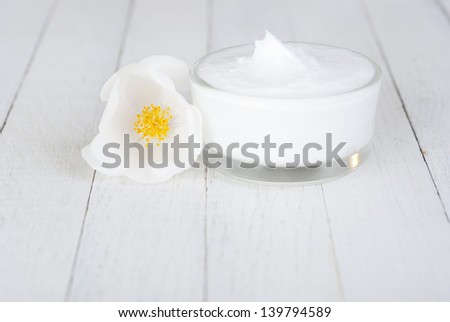moisturizer cream with field roses on white wooden