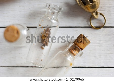 herbs and spices in little bottles, on white wood table