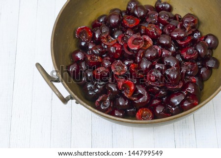 cherry fruits without seeds in a brass bowl on white wood table