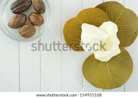 shea butter and shea butter nuts  on white wood