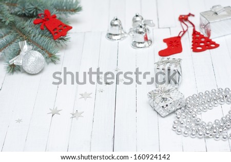 red felt christmas ornaments with pine branch on white wooden table background