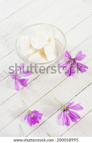 cosmetic cream and flowers on bright wood background