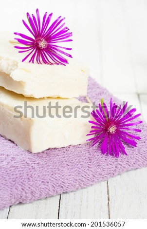 organic soaps and cosmetics with purple flowers on white wooden