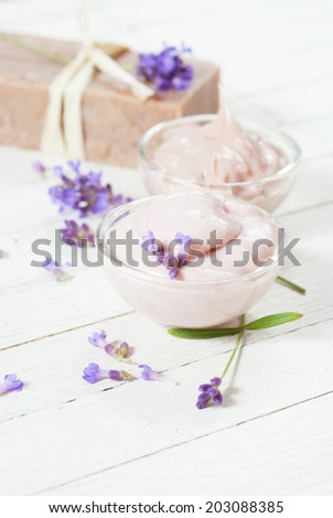 lavender creams and soap with flowers on white wood table