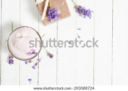 lavender creams and soap with flowers on white wood table