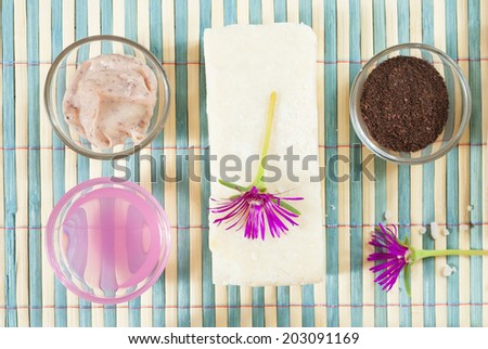spa setting with lavender cream, bath salt and floating flowers on bamboo